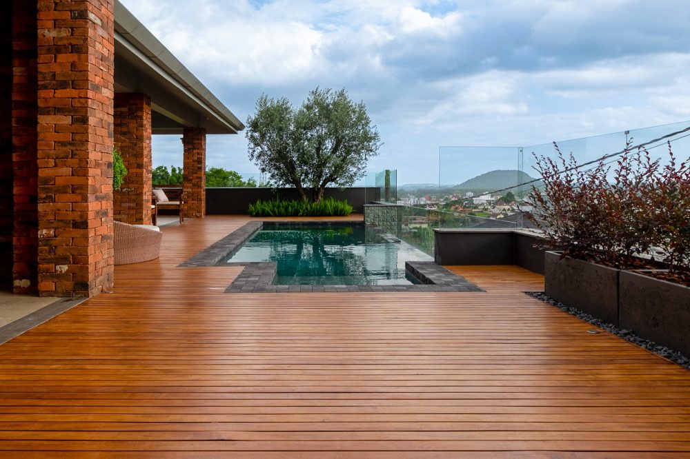 Deck de madeira e piscina, paisagismo por Aline Athaydes
