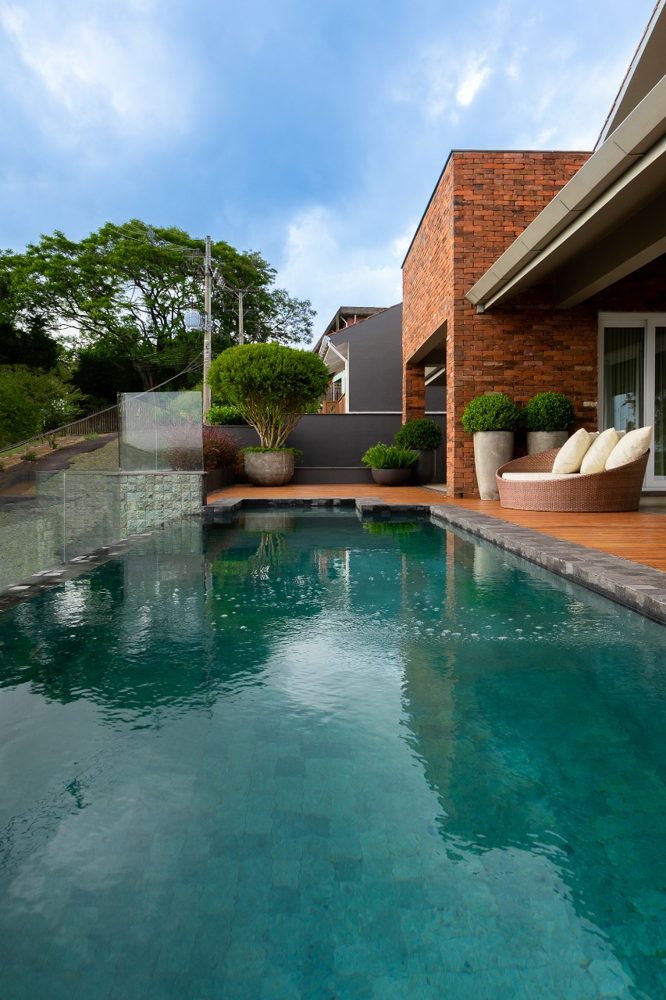 Piscina em área externa residencial, paisagismo por Aline Athaydes