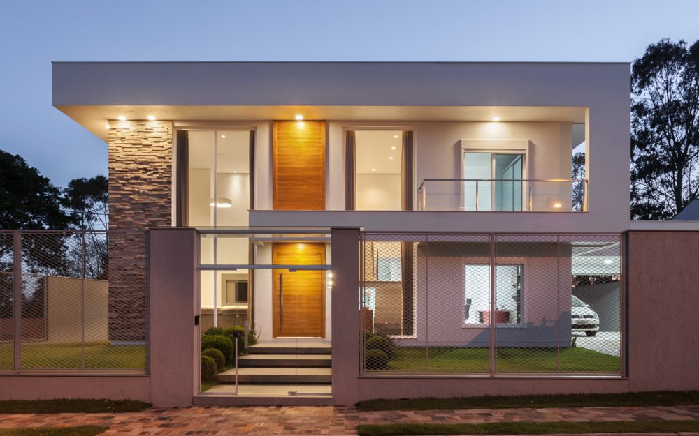 Fachada de residência contemporânea iluminada ao entardecer, projeto Aline Athaydes